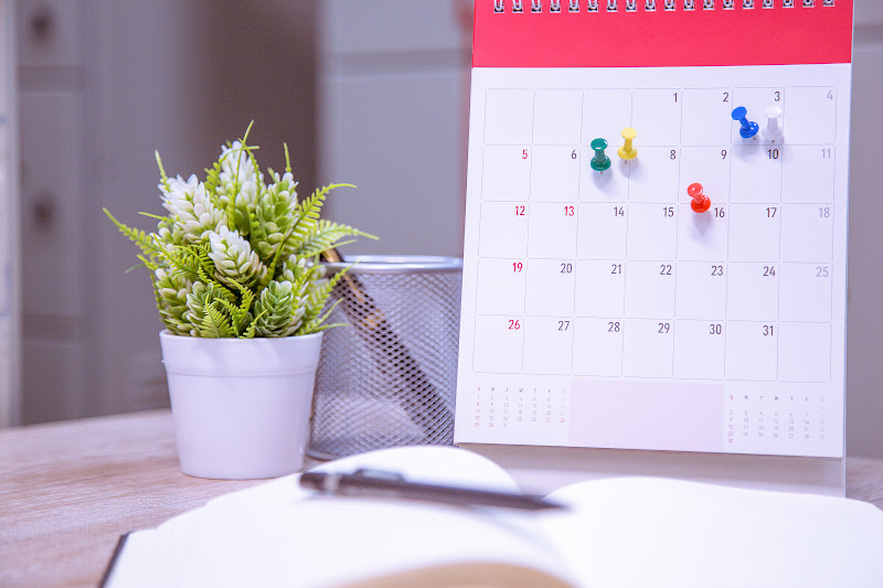 Calendar with colorful pins marking important dates


