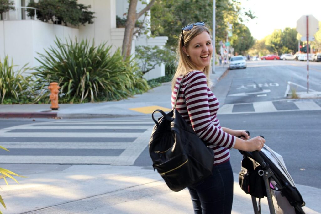 A mom with a backpack is traveling.