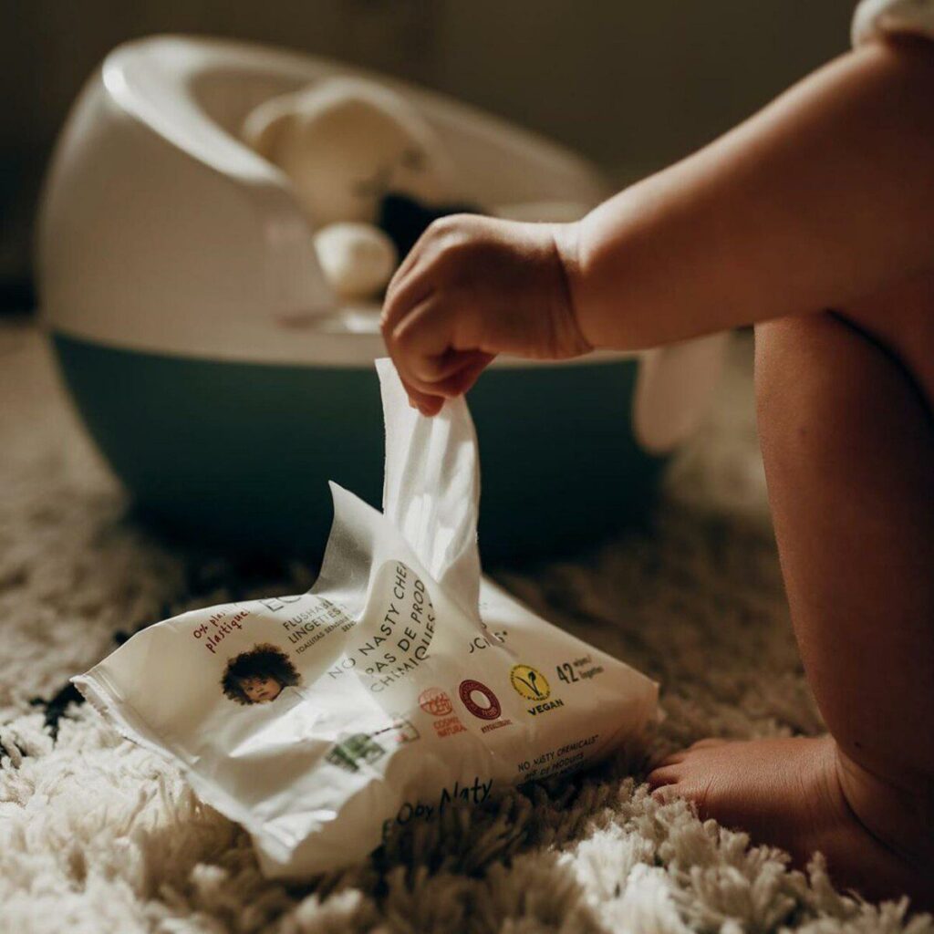 The baby is pulling out a baby wipe.