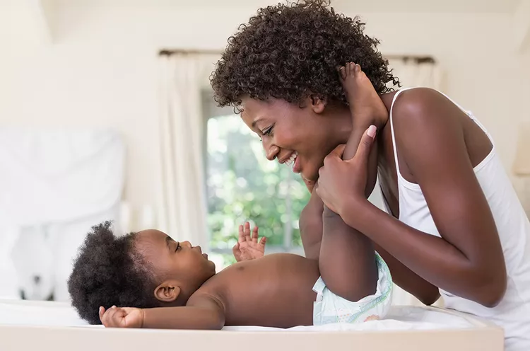 A mother is playing with the baby.