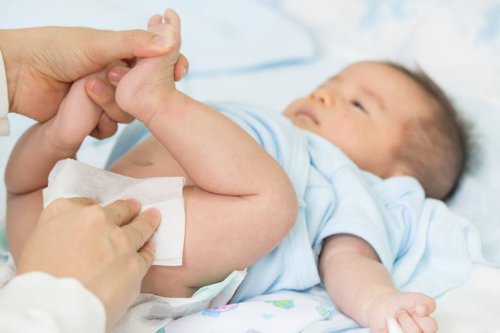 Mother is wiping baby's butt