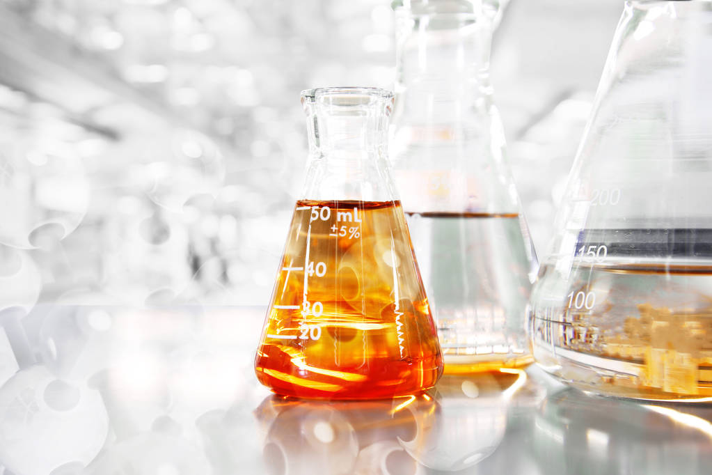 Orange so in conical three flasks with chemical structure in science education laboratory background