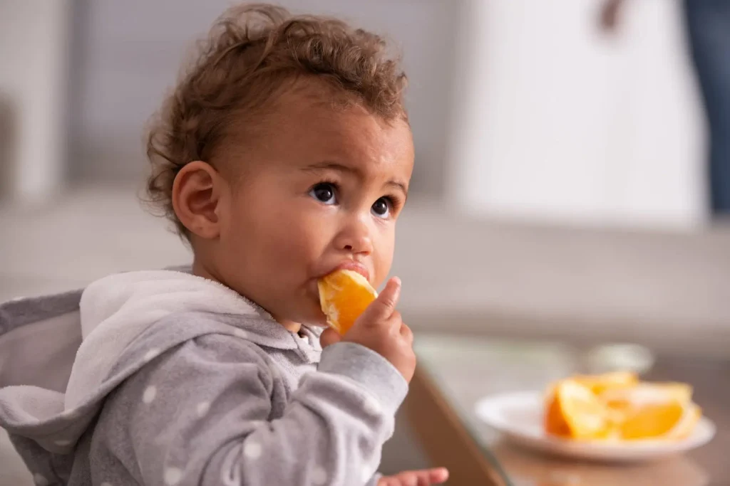 1-year-old baby eating orange